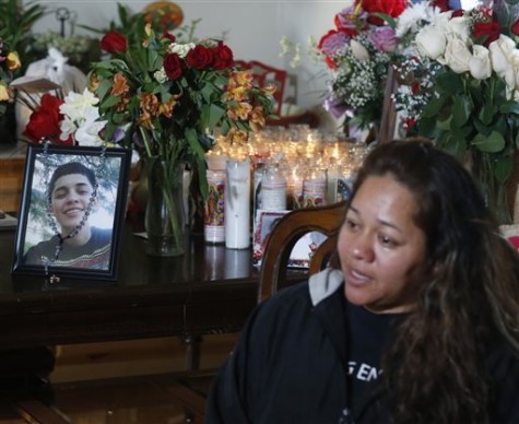 Laura Hernandez talks with reporters in her Thornton, Colo., home on Wednesday, Jan. 28, 2015, about the death of her 17-year-old daughter Jessica, who was killed after she allegedly hit and injured a Denver Police Department officer while driving a stolen vehicle early Monday in northeast Denver alleyway. Photographs of Jessica Hernandez stand on a table covered with bouquets of flowers and a display of candles at back in the family's home.