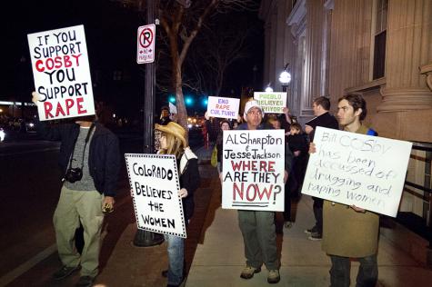 A group holds signs and chants in front of Memorial Hall in Pueblo, Colo., in protest of an appearance there by Bill Cosby Friday, Jan. 16. The show went on despite sexual assault accusations against Cosby by a number of women. 