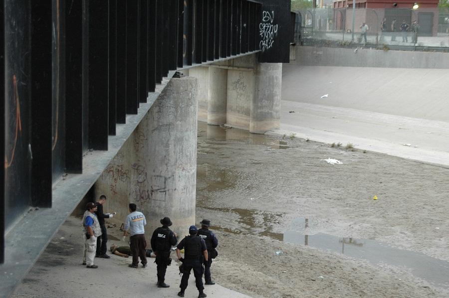 In this June 7, 2010 file photo, Mexican federal police and forensic experts stand next to the body of Sergio Adrian Hernandez Huereca, 15, under the Paso Del Norte border bridge, as U.S. officials watch from the U.S. side at right, in Ciudad Juarez, northern Mexico. On Wednesday, Jan 21, 2015, a federal appeals court in New Orleans revisits the question of whether the Mexican teenagers rights were violated under the U.S. Constitution when he was killed in his home country by a bullet allegedly fired by a federal agent from across the border in Texas.
