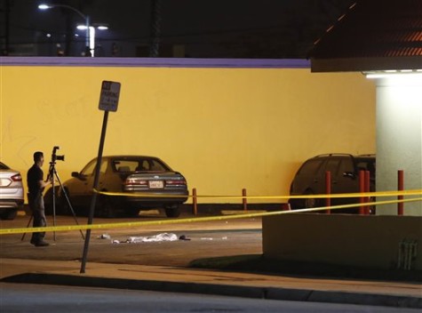 A Los Angeles County Sheriff's Department investigator photographs the scene of an accident at a parking lot in Compton, Calif., Thursday, Jan. 29, 2015. A lawyer for Marion "Suge" Knight, a Death Row Records founder, says Knight was driving a car involved in an accident.