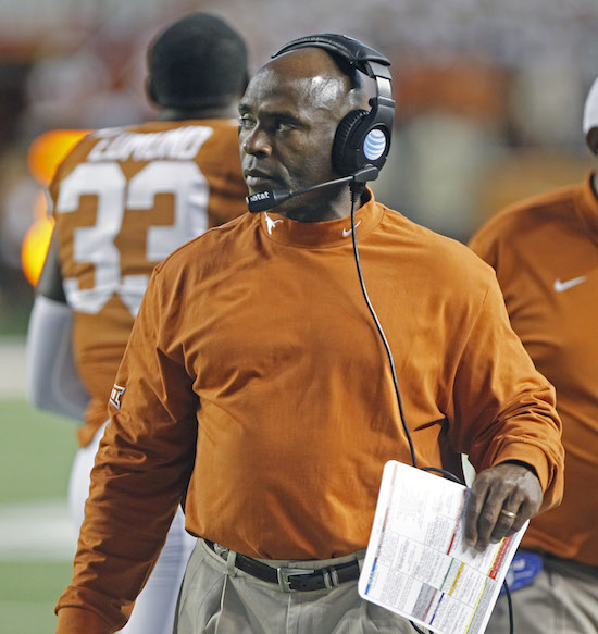 In this Oct. 18, 2014, file photo, Texas head coach Charlie Strong watches from the sideline during  an NCAA college football game against Iowa State in Austin, Texas. The $600,000 question at Texas is just who calls the plays for the Longhorns’ anemic offense. Assistant head coach Shawn Watson says he does. Offensive coordinator Joe Wickline says he does too. In fact, they swear they share. And head coach Charlie Strong? Well, he says they both do, “And I’m on the headset.”