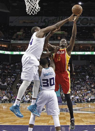Houston Rockets Clint Capela (15) shoots over Charlotte Hornets Troy Daniels (30) and Jason Maxiell (54) during the first half of an NBA basketball game in Charlotte, N.C., Monday, April 13, 2015. 