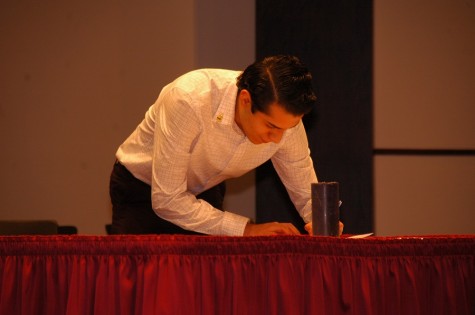 A new Phi Theta Kappa member signs the official membership record at the society’s spring induction ceremony on April 1. 
