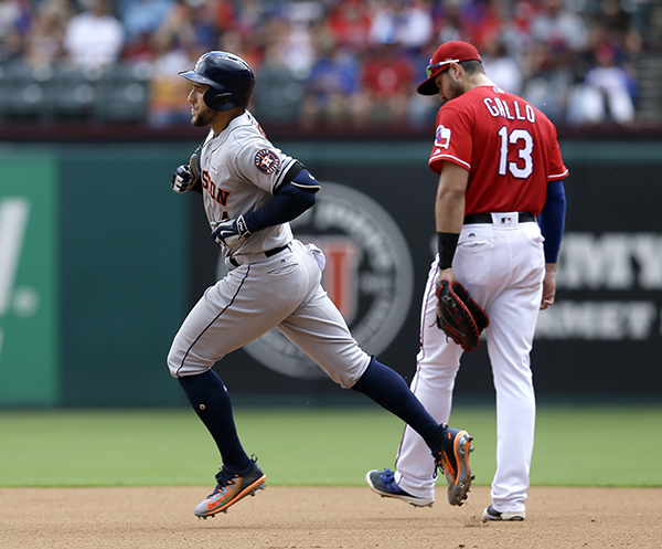 Houston Astros' George Springer, front, rounds the bases. The shot that came off of Rangers starting pitcher Martin Perez was the second of the game for Springer. (AP Photo/Tony Gutierrez)