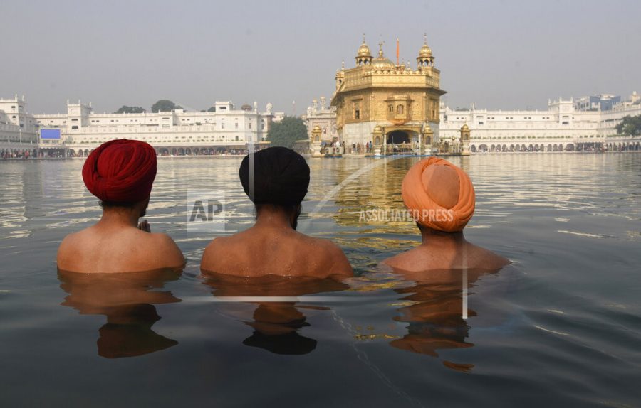 Sikh devotees take a holy dip in the waters of the Golden Temple to mark the birth anniversary of Guru Nanak, the first Sikh Guru, in Amritsar, India, Friday, Nov. 19, 2021. (AP Photo/Prabhjot Gill)