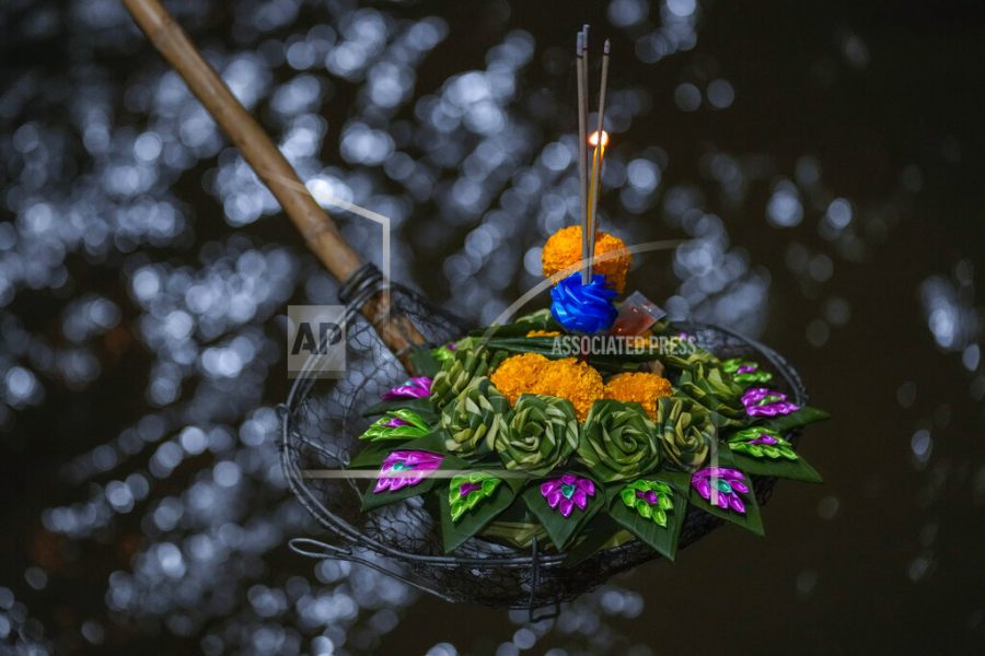 A Thai woman places a krathong, a small boat made of banana tree and decorated with banana leaves and flowers, into Chao Phraya River during Loy Krathong festival in Bangkok, Thailand, Friday, Nov. 19, 2021. As Thais flocked to waterways Friday to release small floats adorned with flowers and candles in an annual festival honoring the goddess of rivers, they also pile trash that clogs drains and canals and pollutes the countrys rivers. (AP Photo/Sakchai Lalit)