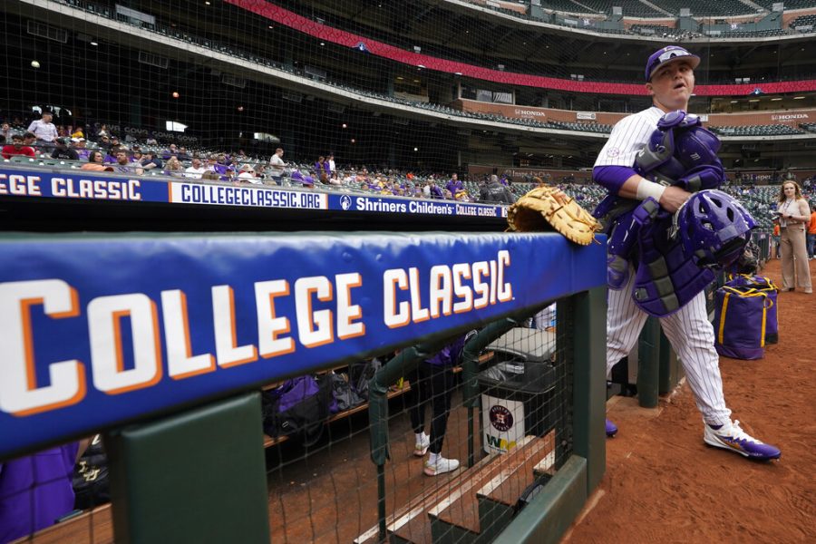 LSU catcher Alex Milazzo carries his gear before an NCAA college baseball game against Oklahoma at Minute Maid Park, home of the Houston Astros, during the Shriners Childrens College Classic, Friday, March 4, 2022, in Houston. College baseball might turn out to be an attractive alternative for baseball fans if the Major League Baseball lockout extends deep into the spring. (AP Photo/David J. Phillip)