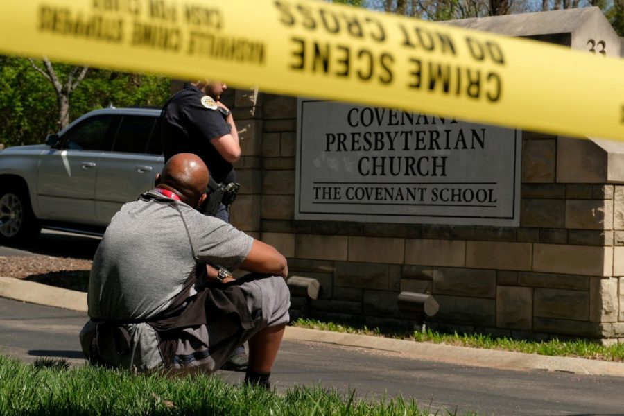 Mario Dennis, one of the kitchen staff at the Covenant School, sits near a police officer after a shooting at the facility in Nashville, Tennessee, U.S. March 27, 2023.  REUTERS/Kevin Wurm  NO RESALES. NO ARCHIVES