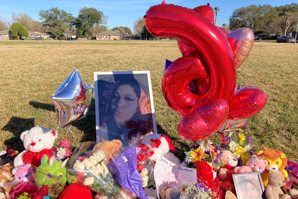 A memorial sits near the side of a street in Houston, next to a large grassy area, where Diamond Alvarez was fatally shot.  