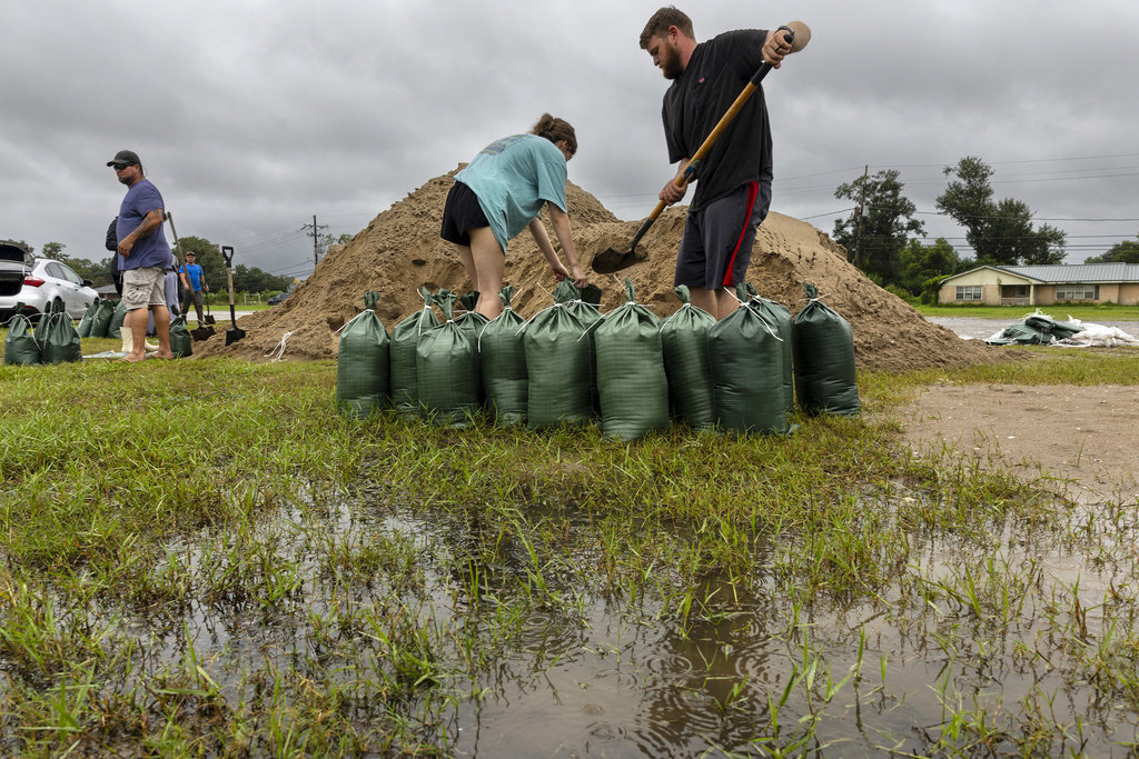 Rainwater accumulates around Nolan and Macie Melancon as they fill up sandbags for their home located a few miles away in Houma, La., as the region gets ready for the arrival of Hurricane Francine on Tuesday, Sept. 10, 2024.