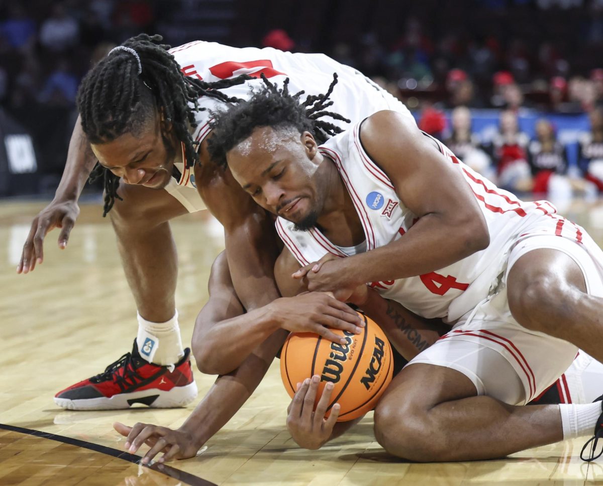 Houston guard L.J. Cryer (4), and Houston forward Joseph Tugler (11) get tied up with SIU Edwardville guard Brian Taylor II during the first half in the first round of the NCAA college basketball tournament, Thursday, March 20, 2025, in Wichita, Kansas.