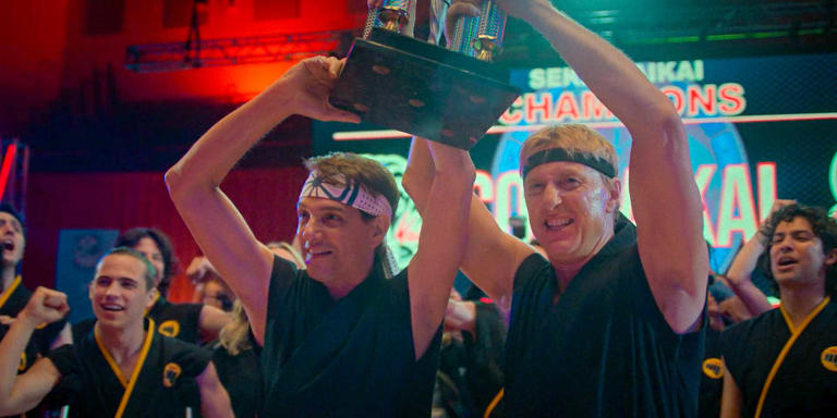 Daniel LaRusso (Ralph Macchio) and Johnny Lawrence (William Zabka) hold Sekai Taikai trophy in finale of Netflix's Cobra Kai.