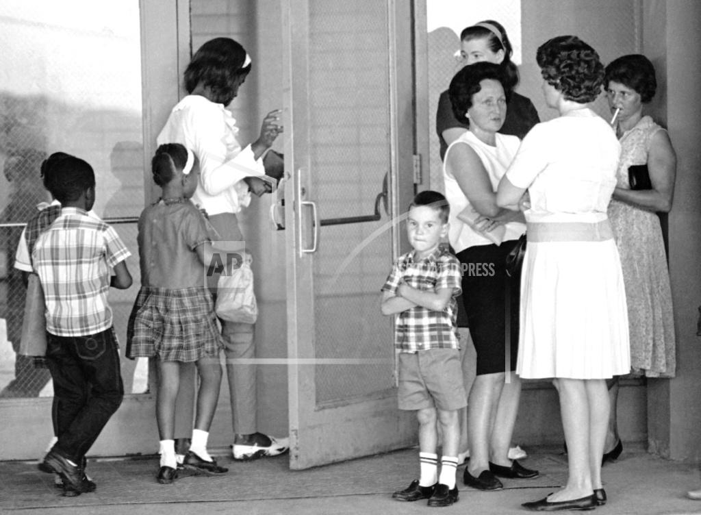 FILE - A group of African American students, left, enter the Boothville-Venice School in Plaquemines Parish, Louisiana on Sept. 12, 1966 as a group of white mothers wait at the entrance of the school. 