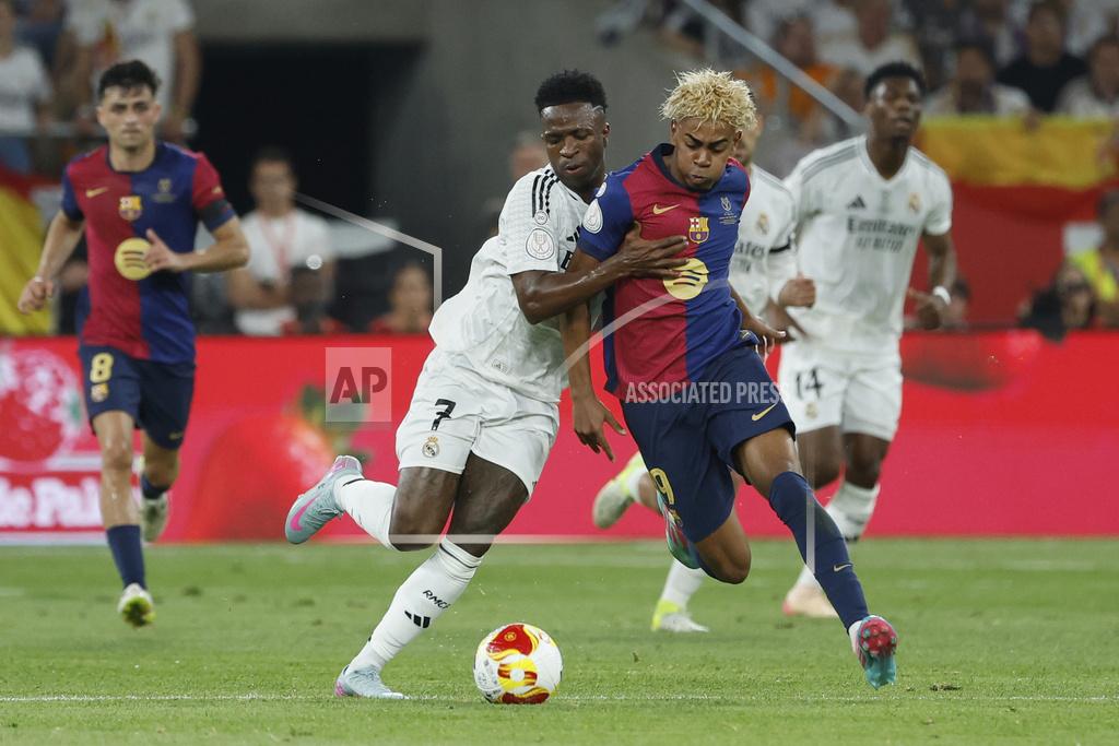 Barcelona's Lamine Yamal, right, fights for the ball with Real Madrid's Vinicius Junior during the Spanish Copa del Rey final soccer match between Barcelona and Real Madrid at Estadio de La Cartuja stadium in Seville, Spain, Saturday, April 26, 2025.