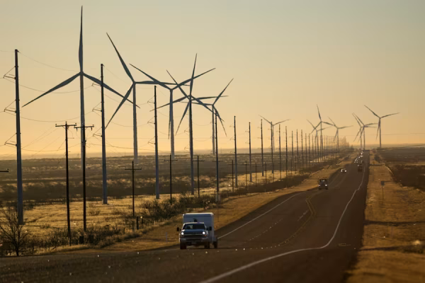 Wind turbines are visible along Route 176 as vehicles travel eastbound Feb. 24, 2025, in Andrews, Texas