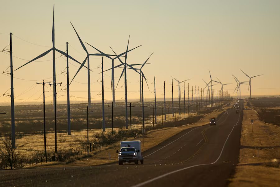 Wind turbines are visible along Route 176 as vehicles travel eastbound Feb. 24, 2025, in Andrews, Texas