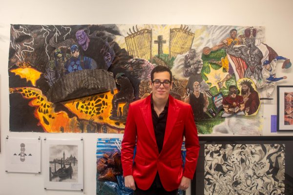 Ruben Rodriguez stands before his artwork exploring the theme of “good vs. evil” at HCC Spring Branch.