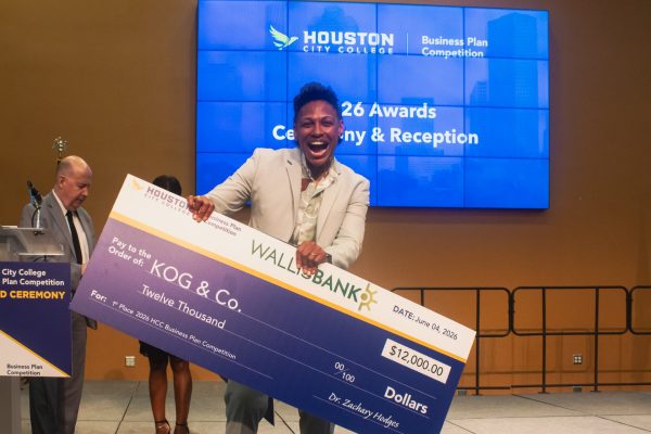 A beaming Khaliah O. Guillory holds the $12,000 first-place prize check after winning for KOG & Company’s Performance Rehab.
